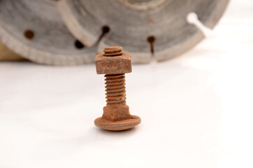 the orange color rusty iron bolt nut isolated on grey white background.