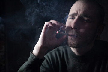 Young man with cigarette in hand feeling lonely and depressed