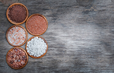 Several types of salt on a wooden background