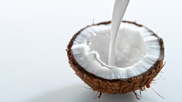Super Slow Motion Shot of Milk Splashing on Fresh Coconut at 1000fps.
