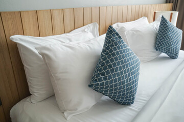 close up comfy white pillows on double bed mattress in luxury hotel bedroom for honeymoon