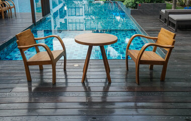Fototapeta na wymiar wooden table and chairs at the poolside for breakfast in luxury hotel