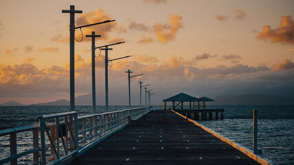 A long jetty and wooden dock by the pier out to sea at sunset, Magnetic Island, Queensland, Australia.