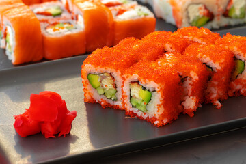 Set of various sushi rolls served on gray background