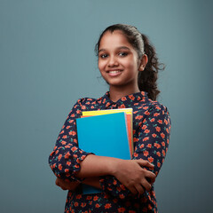 Happy young girl holding note books in her hand