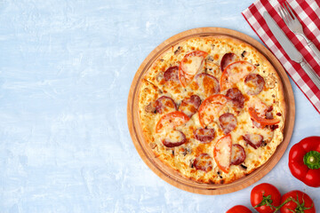 Delicious pizza with sausages on gray background