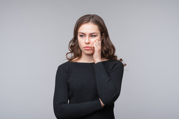 Obraz premium Young beautiful woman looking sad and bored holding hand under chin, got tired at university