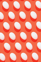 White eggs on glow orange background pattern minimal lay out