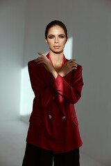 attractive brunette in red jacket holds hands near face charm model