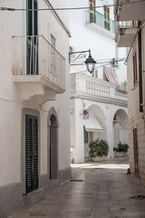 beautiful narrow alley through white buildings in the oldtown of Monopoli in Puglia