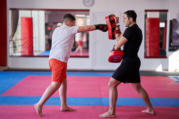 Fototapeta na wymiar Overweight kickboxer with his trainer