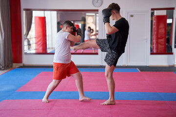 Fototapeta na wymiar Overweight kickboxer sparring with his partner