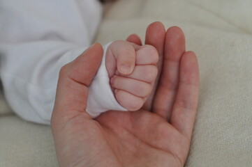 Mother Holding the hand of a newborn baby. Mother Holding Newborn Kid.