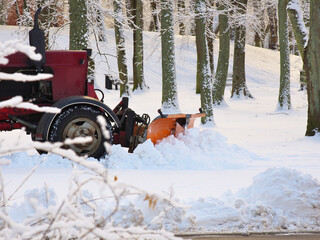 Snow removal with a tractor in the park.
