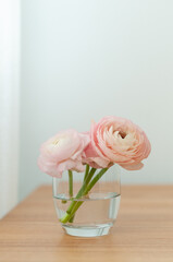 Small bouquet of pink peonies on wooden table