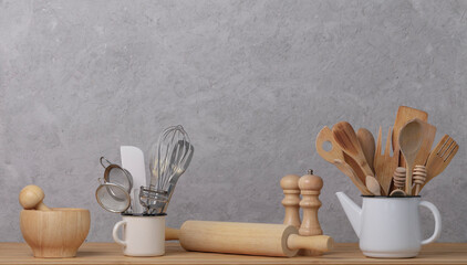 Kitchen tools, utensils and kitchenware on the table on a grey concrete background. Selective focus.