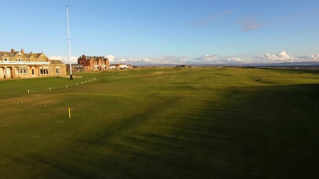 Aerial Forward: Buildings At Golf Course Against Blue Sky