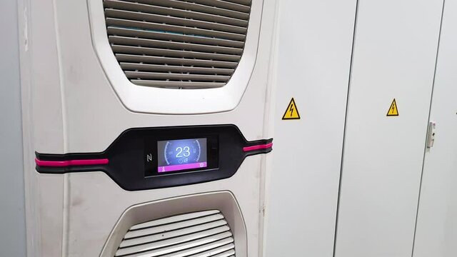 White big industrial conditioner on a door of electric equipment cabinet in automatic control room in a factory.