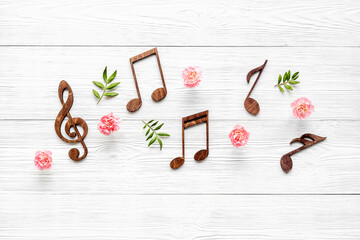 Flat lay of musical notes with flowers. Love songs concept