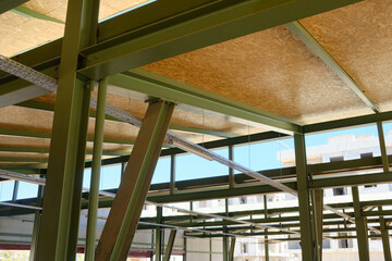 Metal framework of hangar. Metal supporting structures. Beams and girders of truss ceiling.