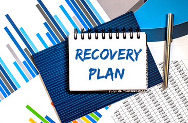 Notebook with text Recovery plan on office table with office supplies on the chart background