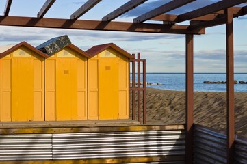 Yellow beach cabins of a bathhouse on the sand in the Mediterranean coast (Pesaro, Italy, Europe)