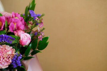 a variety of flowers in a bouquet on a beige background