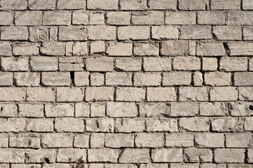 Wall pattern dirty cement assorted bricks. Cement-stained wall from broken bricks