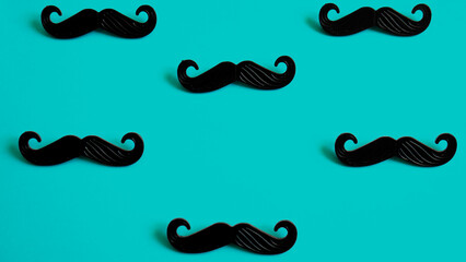 Black mustache on a blue background.  Father's day or man health concept. No shave November month. 