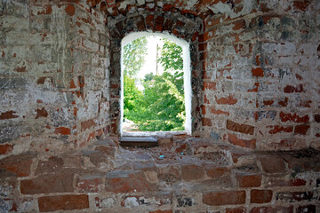 A window in a collapsed stone building. Niche to the street in the old church.