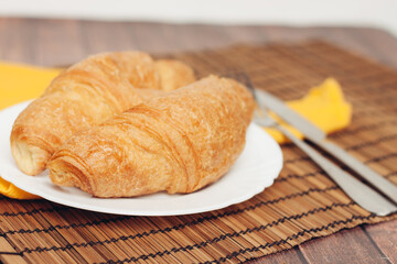 crispy croissants on a plate kitchen utensils for breakfast 