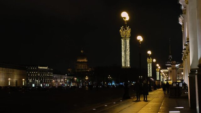 Saint-Petersburg, Russia - December 19 of 2020: residents of the city walking in the evening along the decorated square of the Palace Square. Video in 4k.
