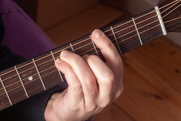 Fototapeta na wymiar Close-up on the hand of a man playing guitar