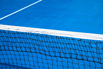Blue tennis court with net. Empty sport field photo. Hard court for lawn tennis. Summer sport activity game outdoor. White markup on blue court. Sunny day on tennis court. Sport field in park - 419576970