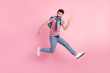 Fototapeta na wymiar Full size photo of happy cheerful smiling handsome man running in air say hello isolated on pink color background
