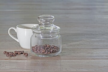 Fototapeta na wymiar A glass bottle with coffee beans on a wooden floor
