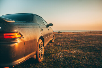 Obraz premium Toyota Mark 2 1996, in the rays of dawn on the seashore