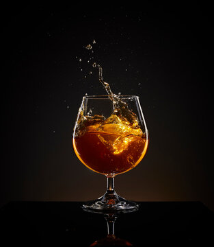 glass of whiskey with ice splash