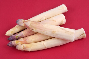 Asperges blanches en gros plan sur fond rouge