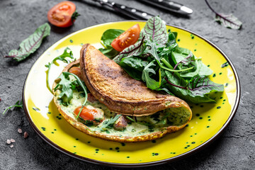 Omelette with cheese, tomatoes Frittata italian omelet on a yellow plate on a gray background. Keto, ketogenic lunch. Food recipe background. Close up