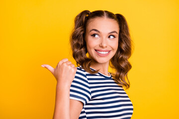 Photo of shiny pretty young lady dressed striped outfit pointing looking back empty space isolated yellow color background