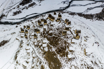 a panoramic view from a drone of an ancient fortress in the snow-capped mountains of Ingushetia 