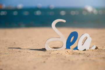 Decorative Sea inscription, woodenl letters on the beach in the sand