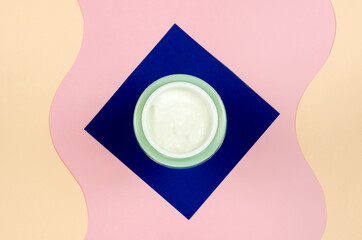 Top view of an open jar of cream on a colored background. Organic cosmetics skincare product