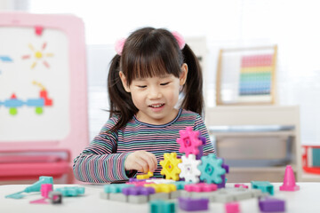 young girl plays creative gear blocks for home schooling