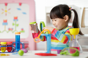 young girl playing color sorting and fine motor skill toy at home