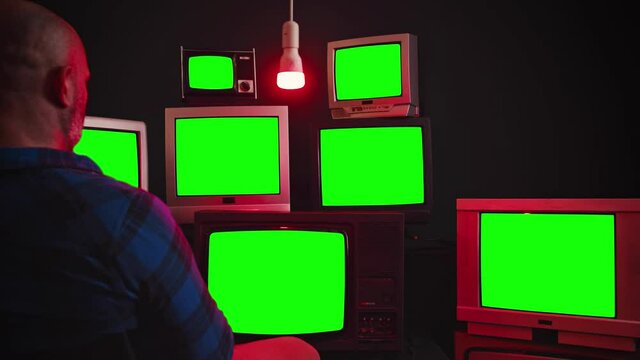 vintage TV's with chroma key screens in room with black wall