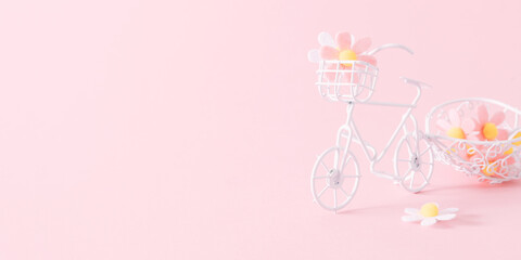 Spring background. Small vintage bicycle with flowers on pink background. Flower delivery minimal concept. Front view. Place for text, copy space, mockup