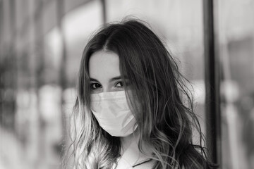 Young female wearing a mask for prevent virus with shopping bags on narrow street in Europe.