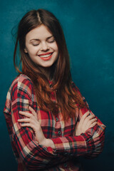 woman in plaid shirt on blue background gesturing with hands cropped view